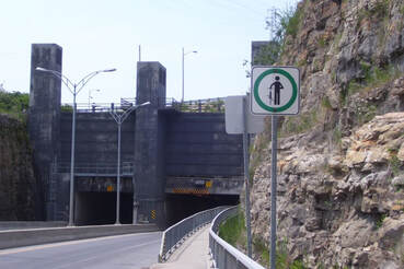 Trottoir étroit à l'entrée d'un tunnel, obligation de marcher à côté du vélo