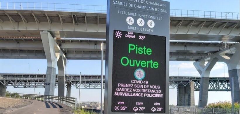 Indicateur numérique avec message « piste ouverte » et une température de 33°, au pied du pont Champlain à Brossard