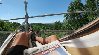 Assis confortablement dans un hamac, lisant un journal allemand, avec le mont Royal (sommet Outremont) devant moi.